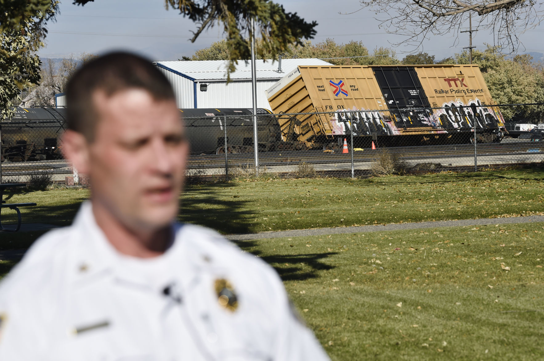 A de-railed train car can be seen of the shoulder of Fire Chief Ken Wood